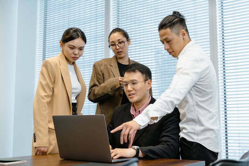 Business team collaborating around a laptop